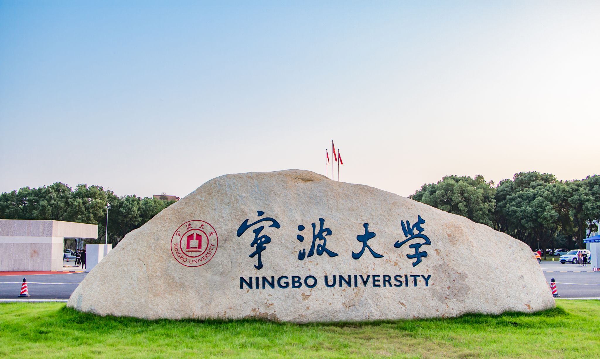 宁波大学校门，绿树与红旗相映